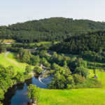 Mae’r afon Dyfrdwy a’r bryniau a choetiroedd | The River Dee and wooded hillsides